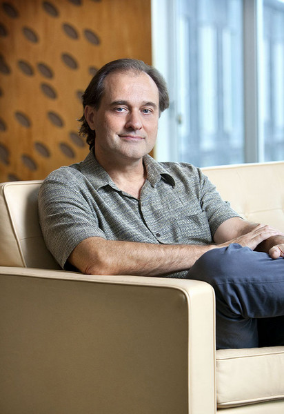 Professor Guy Blelloch seated in a chair in the School of Computer Science Gates building library